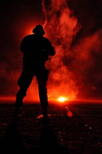 A flare illuminates a U.S. Navy Basic Underwater Demolition/SEAL (BUD/S) third phase trainee during a night shoot on San Clemente Island, Calif., Dec. 3, 2009.