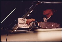 Driver Holding His Car's Test Card as It Proceeds Along the Safety Lane During a Checkup at an Auto Emission Inspection Station in Downtown Cincinnati, Ohio. Since January, 1975, All Vehicles in the City Are Being Checked Once a Year on Safety Requirements Previously They Were Tested Semi-Annually.