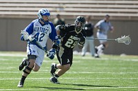 U.S. Air Force Academy senior midfielder Jimmy Curran races by U.S. Military Academy at West Point defender Rob McCallion during the third period of a lacrosse match at Falcon Stadium at the academy in Colorado March 13, 2010.