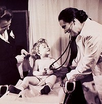 Public health nursing Medical exam. A child, sitting on an obstetrical table, is playing with a physician's stethoscope. Original public domain image from Flickr