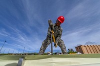 U.S. Air Force Airman 1st Class Adrian Blas, assigned to the 254th Rapid Engineer Deployable Heavy Operational Repair Squadron Engineers, hammers a stake to secure the foundation of an Alaskan Small Shelter System in the village of Koblerville, Saipan, Commonwealth of the Northern Mariana Islands, Nov. 23, 2018.