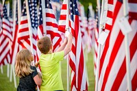 Children read a dedication card on a flag at the Field of Honor at Greenville Town Common, Greenville, date unknown, photo by Aaron Hines. Original public domain image from Flickr