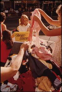 People Looking over Bargains Among Merchandise Placed in Minnesota Street and on Sidewalks by Merchants in New Ulm Minnesota, During Their Annual Crazy Days Sale. The Bulk of the Business District Stores Have Been Revitalized with Community Support.