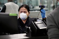 An officer with U.S. Customs and Border Protection Office of Field Operations takes a photo of an arriving international traveler at Dulles International Airport in Dulles, Va., March 18, 2020.