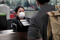 An officer with U.S. Customs and Border Protection Office of Field Operations reviews travel documents of an arriving international traveler at Dulles International Airport in Dulles, Va., March 18, 2020.