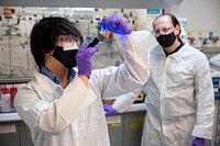 Scientists in lab, looking at test tube. Argonne National Laboratory, December 7, 2020. Original public domain image from Flickr