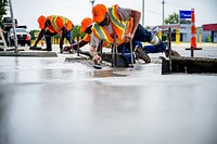 Public Works Streets Division constructs an ADA-compliant crosswalk ramp on E 10th Street, August 28. Original public domain image from Flickr