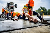 Public Works Streets Division constructs an ADA-compliant crosswalk ramp on E 10th Street, August 28. Original public domain image from Flickr