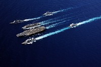 The aircraft carrier USS Abraham Lincoln (CVN 72), bottom center, and the Military Sealift Command fast combat support ship USNS Rainier (T-AOE 7), top center, cruise in formation with ships from the Abraham Lincoln Carrier Strike Group during an underway replenishment in the Pacific Ocean Sept. 19, 2010.