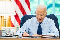 President Joe Biden talks on the phone with U.S. Senator Tom Carper, D-Del., during congressional call time on Friday, July 16, 2021, in the Oval Office of the White House. (Official White House Photo by Adam Schultz). Original public domain image from Flickr