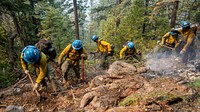 Blue Ridge Hot Shots dig a fireline on a steep-sloped mountain to suppress the Dixie Fire in Lassen National Forest, California. USDA Forest Service photo by Cecilio Ricardo. Original public domain image from Flickr