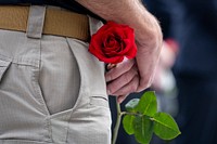 Man holding red rose. Original public domain image from Flickr