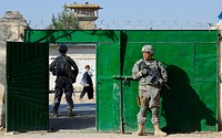 U.S. Army Pfcs. Nicholas Sudano, right, and Nicholas Querzoli, both assigned to the Zabul Provincial Reconstruction Team, secure the gate to the construction site of a radio station and media center while engineers inspect the project site in Qalat, Afghanistan, Nov. 6, 2010.