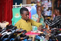 Young man selling shoes. Original public domain image from Flickr