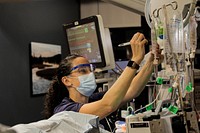 Darcy Guerricagoitia changes sedative medication of a trauma patient to ensure the patient remains comfortable while on the ventilator providing respiratory support at Billings Clinic Hospital in Billings, Montana, Nov. 12, 2021. (U.S. Army photo by Sgt. Andre Taylor) Original public domain image from Flickr