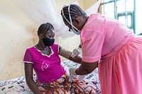 Mamsu Kanu is attended to by Nurse Gladys Nicol at Mawoma Health Clinic, Port Loko, Sierra Leone on 10th August 2021. Original public domain image from Flickr