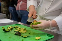 Cutting avocado, kitchen preparation, culinary team. Original public domain image from Flickr