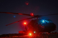 An UH-60L Black Hawk aircrew assigned to Alpha Co., 3-10 GSAB, equipped with the Volcano landmine system, gets ready to take off at night during JRTC. Original public domain image from Flickr