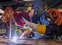 Hull Technician 3rd Class Kyle Mehle, from Bedford, Pennsylvania, welds carbon steel stock aboard the Nimitz-class aircraft carrier USS Harry S. Truman (CVN 75).