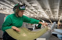 Aviation Structural Mechanic 2nd Class Lucia Romero, from Norwalk, California, assigned to the “Fighting Checkmates” of Strike Fighter Squadron (VFA) 211, cleans a panel from an F/A-18E Super Hornet in the hangar bay of the Nimitz-class aircraft carrier USS Harry S. Truman (CVN 75). The Harry S. Truman Carrier Strike Group is on a scheduled deployment in the U.S. Sixth Fleet area of operations in support of naval operations to maintain maritime stability and security, and defend U.S., allied and partner interests in Europe and Africa. (U.S. Navy Photo by Mass Communication Specialist Third Class Tate Cardinal)