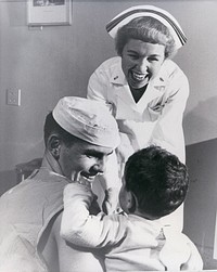 Navy Nurse Lieutenant Junior Grade Lucille F. Neary, of Emerysville, California and her assistant Hospital Corpsman 3rd Class Paul J. Altman, Jr. of Greensburg, Pennsylvania, seem to enjoy their duties on a children's ward of the U.S. Naval Hospital, Bethesda, Maryland. [Nurses. Nursing.] [Pediatrics.] [Portraits.] [Women.]  