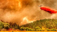 2021 USFWS Fire Employee Photo Contest Category: Aircraft - WinnerAn aircraft drops fire retardant on the 2021 Richard Spring Fire in Montana near a residence. Photo by Phil Millette, FWS