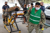 CAMP LEMONNIER, Djibouti (Jan. 26, 2022) U.S. Navy Hospital Corpsman 3rd Class Edward Terronestaipe, from Queens, N.Y., escorts a simulated patient into Michaud Expeditionary Medical Facility during a mass casualties exercise on base. CLDJ serves as an expeditionary base for U.S. military forces providing support to ships, aircraft and personnel that ensure security throughout Europe, Africa and Southwest Asia. The base enables maritime and combat operations in the Horn of Africa while fostering positive U.S.-Africa relations. (U.S. Navy photo by Mass Communication Specialist 1st Class Jacob Sippel)