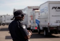 An officer with U.S. Customs and Border Protection Office of Field Operations observes a line of trucks awaiting their turn to be scanned during Non-Intrusive Inspection operations near SoFi Stadium in Inglewood, Calif., Feb. 8, 2022. CBP Photo by Glenn Fawcett