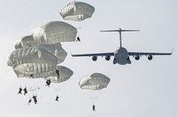 Air Force and Army conduct airborne operations at JBERArmy paratroopers from the 4th Infantry Brigade Combat Team (Airborne), 25th Infantry Division, U.S. Army Alaska, descend over Malemute Drop Zone after jumping from a U.S. Air Force C-17 Globemaster III during airborne training at Joint Base Elmendorf-Richardson, Alaska, March 24, 2022. Army and Air Force units regularly train together to strengthen and maintain joint mission readiness skills in an arctic environment. Air crew from the 62nd Airlift Wing, Joint Base Lewis-McChord, Washington, provided air support for the training. (U.S. Air Force photo by Alejandro Peña)