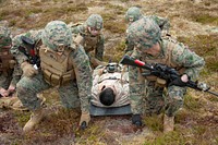 U.S. Marines and Sailors with 24th Marine Expeditionary Unit (MEU) transport a casualty role-player as a part of amphibious security operations during a training exercise. Tarva, Norway, May 14, 2021.  Original public domain image from Flickr