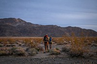 Researchers hiking towards a mountain range, southern California