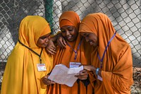 Girl students check their names on a list outside an examination center for Primary Education Certificate examinations in Mogadishu, Somalia, May 26, 2021. AMISOM Photo / Mokhtar Mohamed. Original public domain image from Flickr