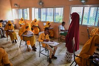 Invigilator monitors students sitting for their Primary Education Certificate examinations in Mogadishu, Somalia, May 26, 2021. AMISOM Photo / Mokhtar Mohamed. Original public domain image from Flickr