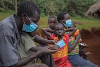 Caretaker reads malaria prevention information card.