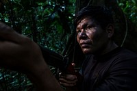 Man holding gun in the Amazon rainforest. August 27, 2016. (USDA Forest Service photo by Diego Perez) Original public domain image from Flickr