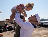 Logistics Specialist 2nd Class Austin Slater, assigned to the Arleigh Burke-class guided-missile destroyer USS Roosevelt (DDG 80), reunites with his family on the pier. (U.S. Navy photo by Mass Communication Specialist 2nd Class Andrea Rumple). Mediterranean Sea, August 3, 2021. Original public domain image from Flickr