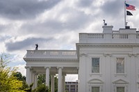 A U.S. Secret Service Counter Assault Team agent is seen on top of the White House. Original public domain image from Flickr