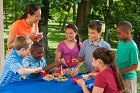 Children participating in nutrition education at a summer meals site. Teacher and children making pasta salad. Original public domain image from Flickr