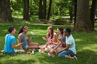 Teens eating at a summer meal site in a park. Original public domain image from Flickr