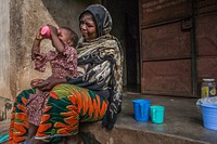 Mariama Djoulde Diallo and her aunt Mariama Laoubhe Diallo (58 years old) are happy that the little one has taken her dose of SP-AQ to protect herself against malaria. Photo by USAID/RTI. Original public domain image from Flickr