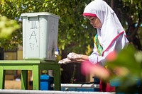 Girl washing hands. Original public domain image from Flickr