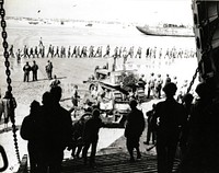 Casualties are brought aboard an LST for removal from the beachhead. In the background are German prisoners under guard. Normandy Invasion, June 1944. [World War II]