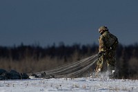 Air Force and Army conduct joint airborne operations at JBERA U.S. Army paratrooper assigned to the 2nd Battalion, 377th Parachute Field Artillery Regiment, 2nd Infantry Brigade Combat Team (Airborne), 11th Airborne Division, “Arctic Angels,” recovers his jump gear during airborne training at Malemute Drop Zone, Joint Base Elmendorf-Richardson, Alaska, Nov. 9, 2022. The 2/11 IBCT (A) is the only airborne infantry brigade combat team in the Arctic and Pacific theaters, providing the combatant commander with the unique capability to project an expeditionary force by air. (U.S. Air Force photo by Alejandro Peña)
