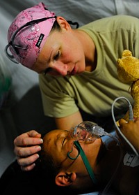 U.S. Army Staff Sgt. Virginia Andrews-Arce, a senior licensed practical nurse with the 541st Forward Surgical Team, comforts Hamed, a five-year-old Afghan boy, following surgery to repair the boy?s broken leg at Camp Pannonia, Afghanistan, Dec. 19, 2010.