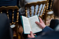 A guest consults a program while President Joe Biden delivers remarks at a Saint Patrick’s Day event, Thursday, March 17, 2022, in the East Room of the White House. (Official White House Photo by Cameron Smith)