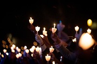 People holding candles to pray.