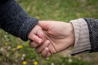 Mother holding baby's hand.