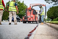 Pavement crack sealing being performed along Red Banks Road, Greenville, June 14, 2022. Original public domain image from Flickr