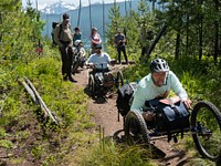 Hiking the Rocky Point TrailA group of people hike along the Rocky Point Trail, some using mobility devices like handcycles. Wheelchairs and other hand- and battery-powered mobility devices are allowed on all park trails