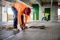 A contractor performs maintenance replacing all expansion joint seals on the 4th Street Parking Deck on Monday, July 11, 2022. Original public domain image from Flickr